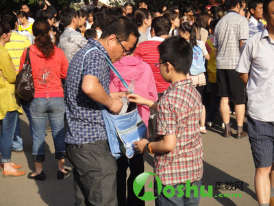 进入考场前,爸爸帮忙将考试用具从书包中拿出来