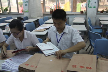 老师认真审查荣誉证书资料